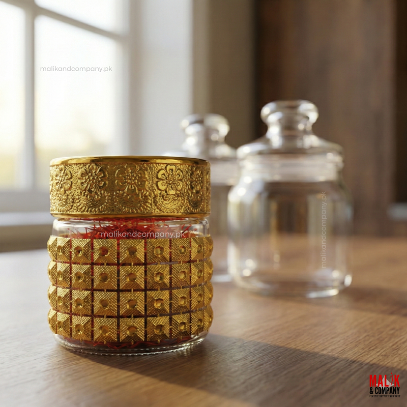 Decorative glass jar with gold embellishments on a wooden surface for saffron