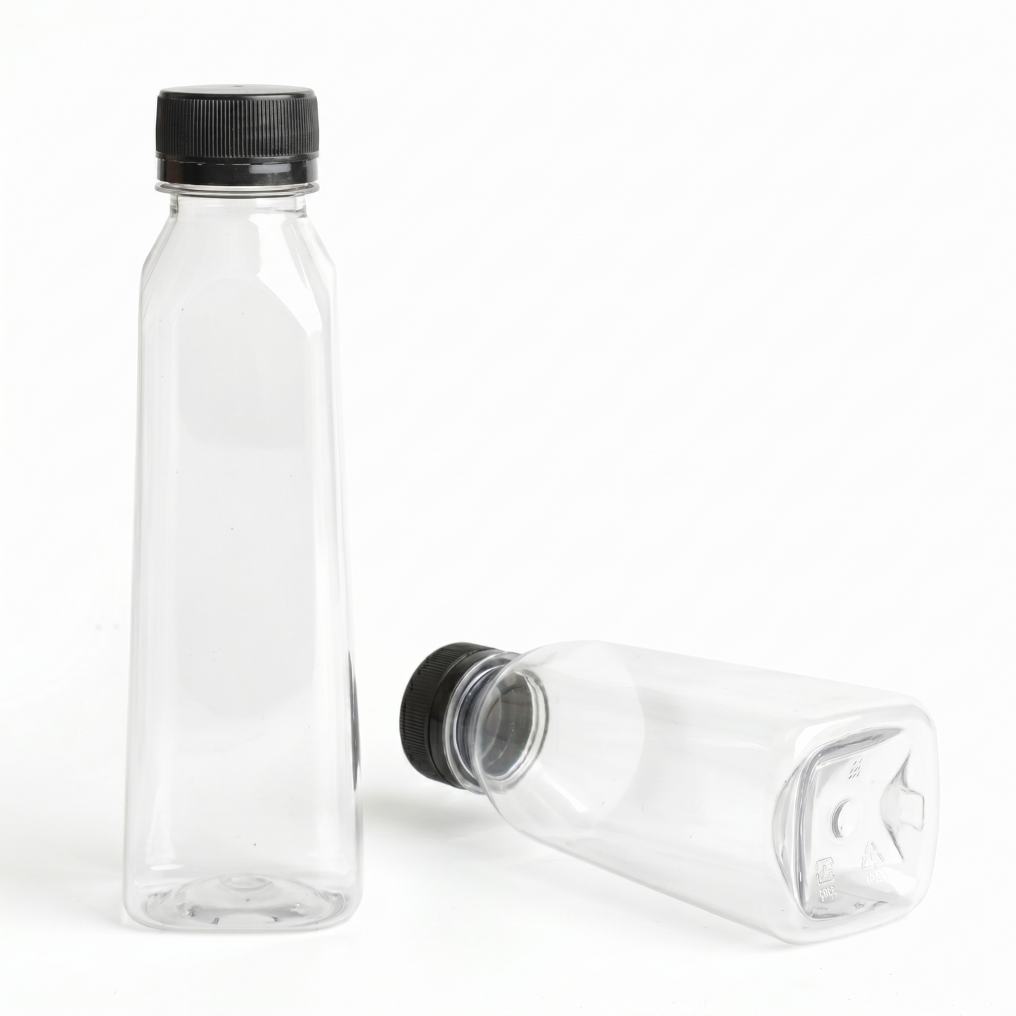 An upright 250ml clear PET bottle with the black cap standing separately, demonstrating the packaging solution components before assembly.